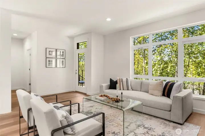 Walls of windows flooding in natural light from your greenbelt view