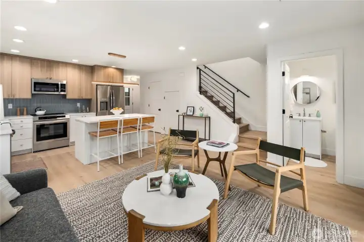 Open concept living includes convenient powder room and open staircase