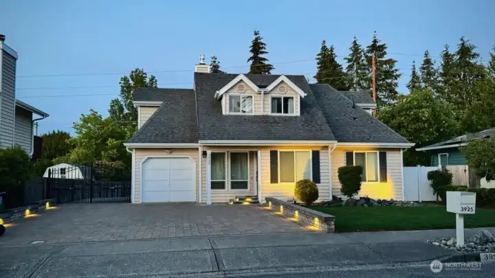 The paver driveway features accent lighting.