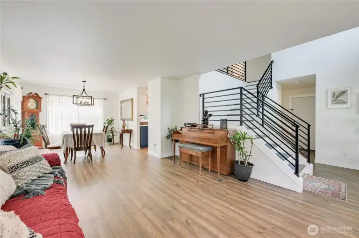 Living room and dining area shows off the floors.  Stylish metal railing at the stairs.