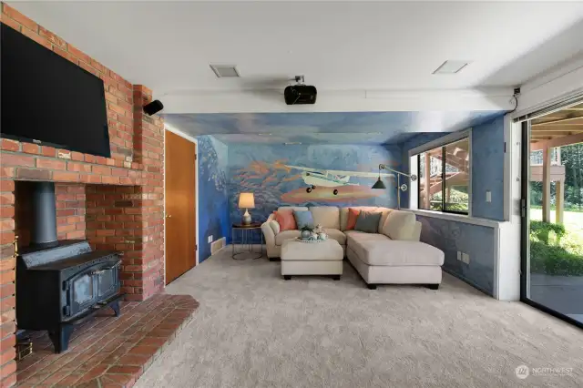 The large bonus room on the ground level,  which doubles as a movie theater , provides  a perfect setting for noisy gatherings while  maintaining a serene atmosphere on the  upper level. Built-in projector and speakers  included!