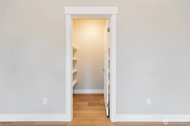 Storage area with custom shelving off of living room.