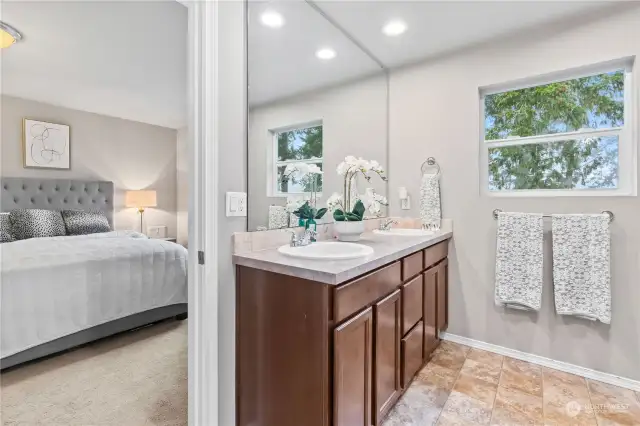 Primary bath off bedroom with double sinks and tub/shower