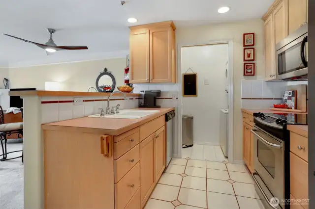 Kitchen is open to the dining and living area so you are always part of the action when you entertain. Notice the stacked washer/dryer on the right. There is shelving for extra pantry to the left.