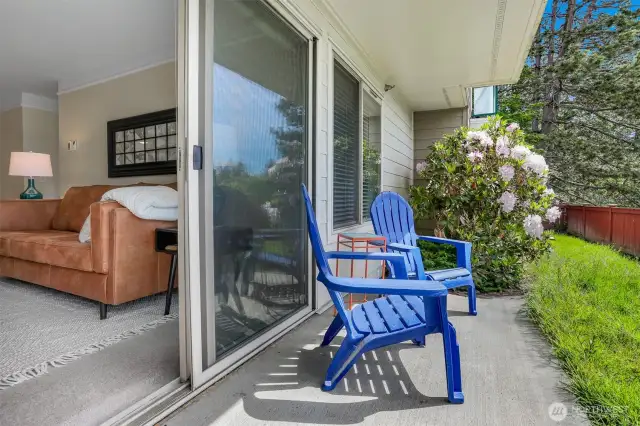 The living area flows to a sunny patio and grassy space - ideal for pets and outdoor lounging.