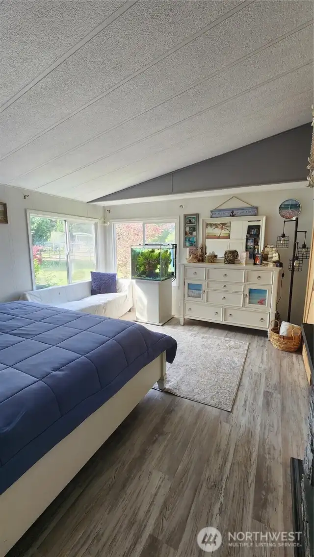 The primary bedroom is filled with natural light and offers a view of the pasture.