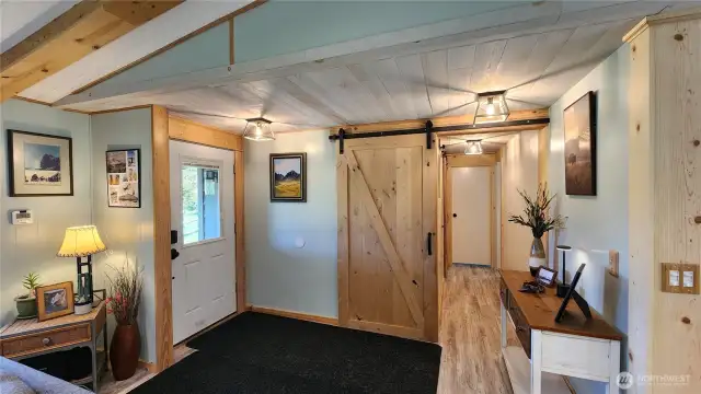 The warm entrance area leads to a hallway that extends toward the primary suite.