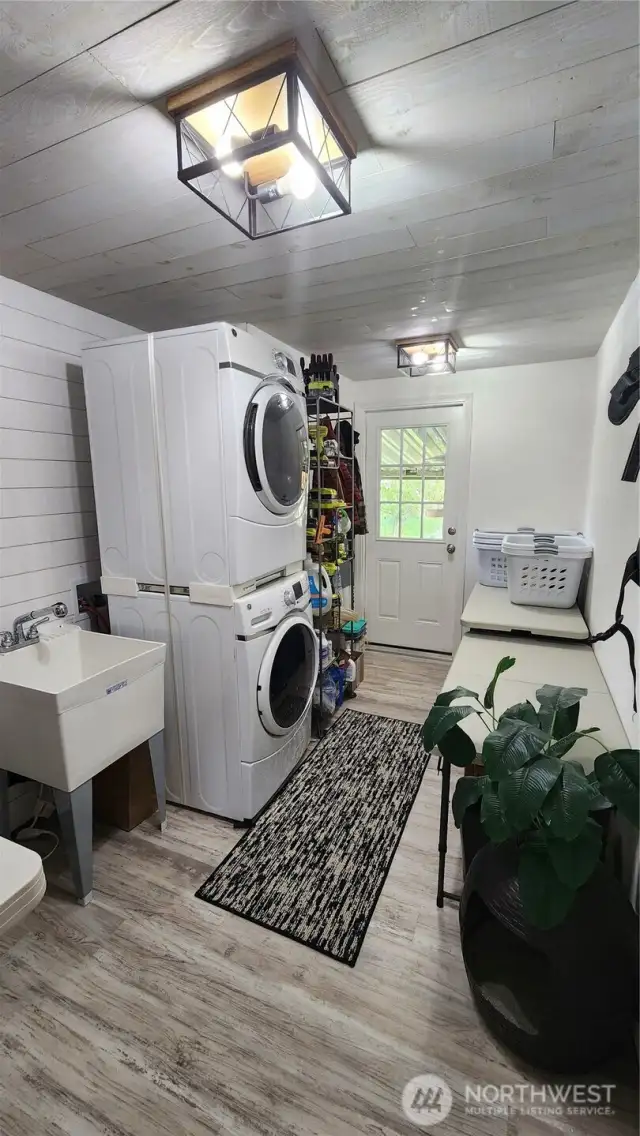 Renovated laundry/utility room with shiplap, new flooring and light fixtures.