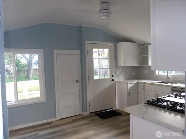 Entering kitchen from living room. The door you see here goes outside to the deck and back yard.
