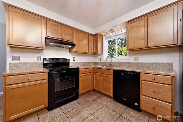 Such a nice modern kitchen with tile counters and floor!