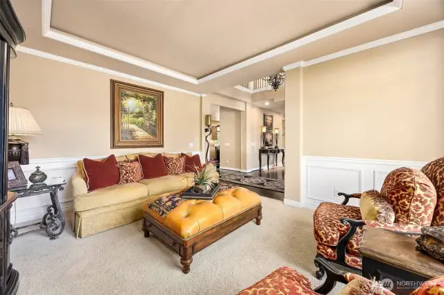 Enhanced with rich crown molding and  stunning coffered ceilings this formal living  room has an abundance of natural light.