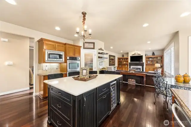 Open kitchen features slab granite  countertops, a custom-designed island  perfect for gathering or just a quick  breakfast, a spacious walk-in pantry. The  window overlooks the lush & private  backyard.