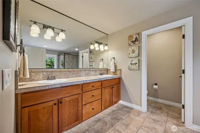 Primary ensuite has tile floors, double vanities, lots of cabinets with a separate water closet.