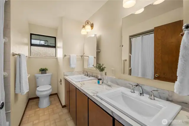 Main bathroom with shower/tub combo and dual sinks.