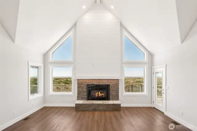2-story vaulted ceiling with custom propane fireplace and under-mantle lighting. Deck access from the living room amd those ocean views.