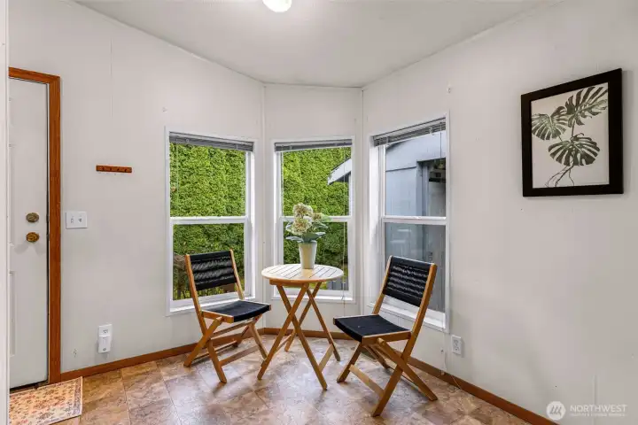 Entering the back door off of the carport, this is the cozy bright breakfast nook area.  Laundry area is to your far left, not seen in this picture.  See those tall arborvitaes?  Absolute privacy!!