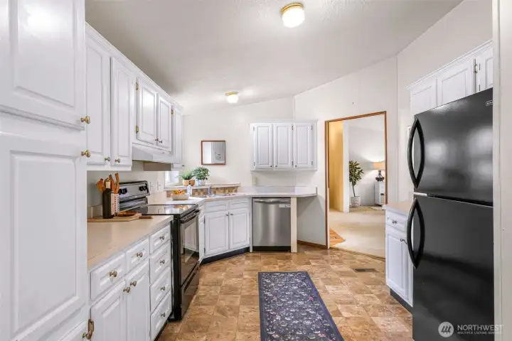 This kitchen is ready and waiting your special touches!  The living room is seen to through the doorway.  All appliances stay. Yes, there's a dishwasher, stove, refrigerator, just bring your microwave if you use one.