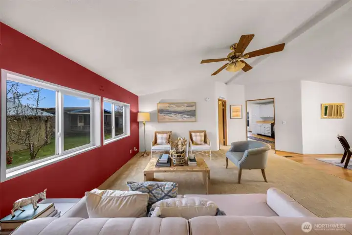 This is a great shot of the living room and you notice the primary bedroom suite doorway at center, the kitchen a slight right and the dining room to your right.