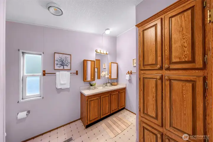 Primary suite full bathroom with plenty of supply closets (don't miss the closet around the far right corner!).