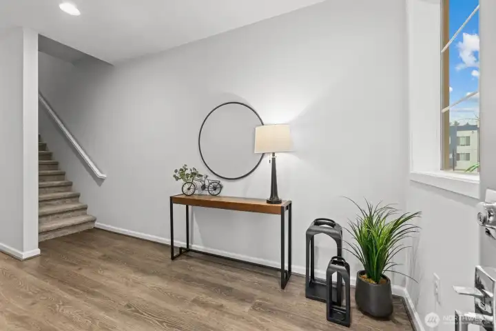 Foyer leading to the garage & stairs up to the upper levels (staged)