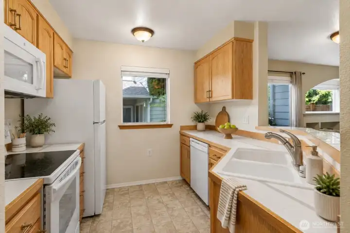 The functional layout of this kitchen keeps everything within reach while maintaining connection to the rest of the home.  [Photo is virtually staged.]