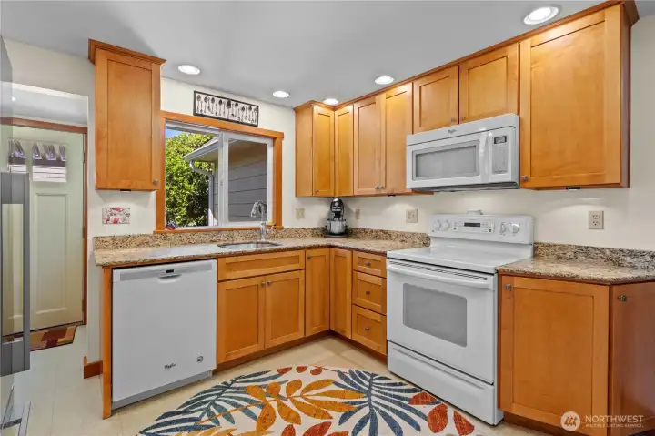 Kitchen with Newer White Appliances: Stove/Range, Microwave and Dishwasher. Recessed Lighting and Under Cabinet Lighting.