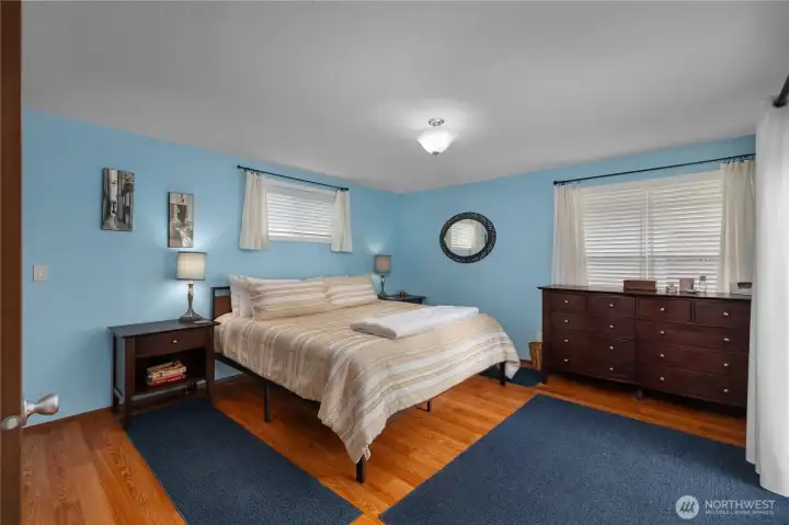 Spacious primary bedroom features direct deck access, abundant natural light, and convenient access to the five piece bath Spacious primary bedroom features direct deck access, abundant natural light, and convenient access to the five piece bath