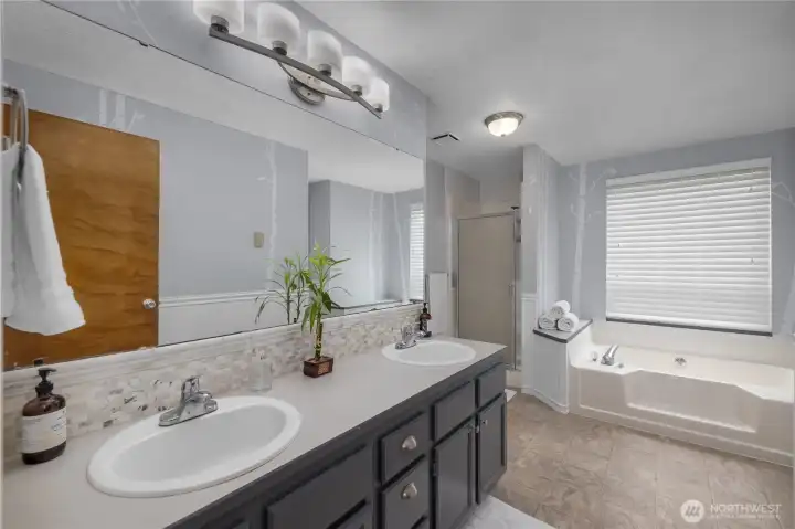 Spacious primary bath features dual vanities, a soaking tub, and a separate shower for everyday comfort and convenience Spacious primary bath features dual vanities, a soaking tub, and a separate shower for everyday comfort and convenience