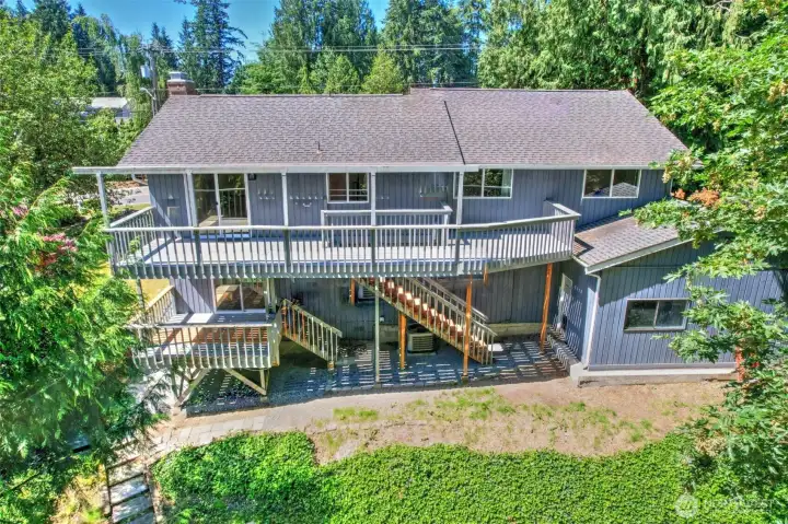 terraced yard surrounded by natural setting of evergreens for privacy and enjoyment