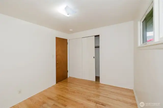 Closet space is thoughtfully integrated with sliding doors, providing practical storage while maintaining a clean and open feel.