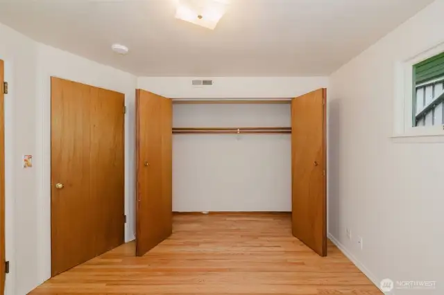 Closet space is thoughtfully integrated with sliding doors, providing practical storage while maintaining a clean and open feel.