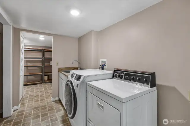 Laundry with a real sink close by! There is lots of storage in this house. Through the doorway the shelves will stay and there is another storage room to the right