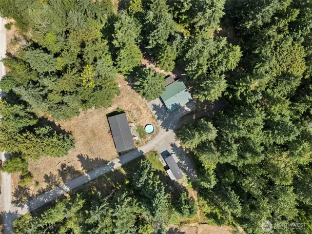 Home, RV parking spots and covered outdoor area surrounded by privacy from mature trees.