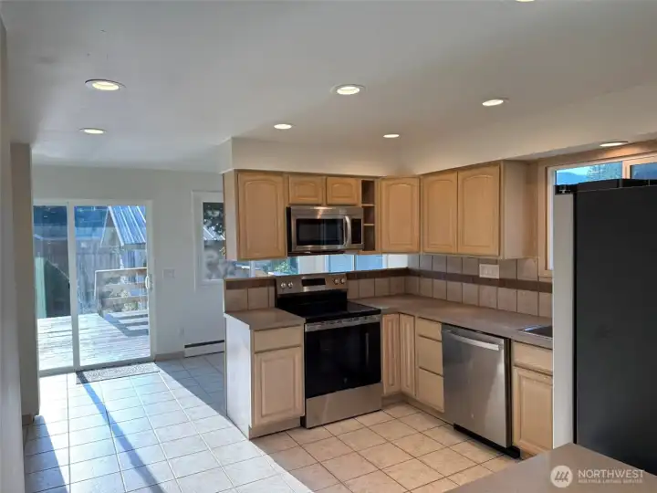 Kitchen view towards breakfast nook & sliding door to back deck