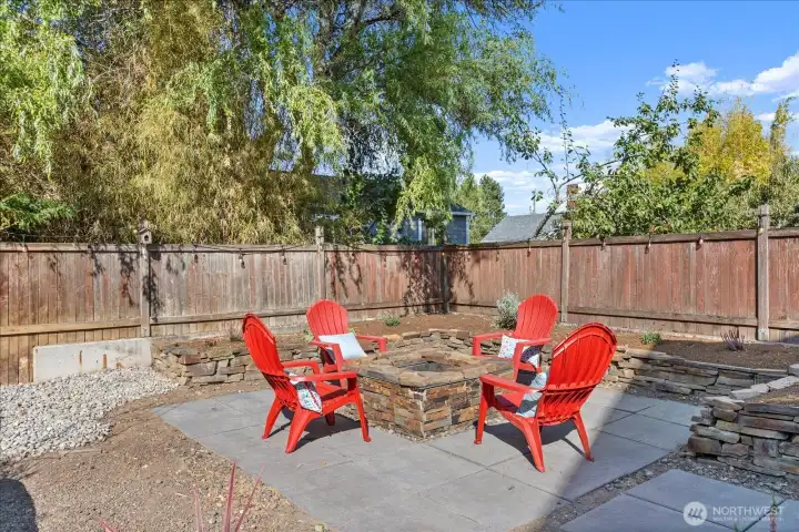 Garden beds and fruit trees line the backyard