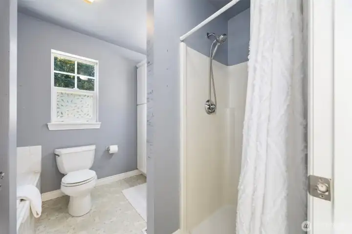 The ensuite off the primary bedroom with it's stall shower & soaking tub.