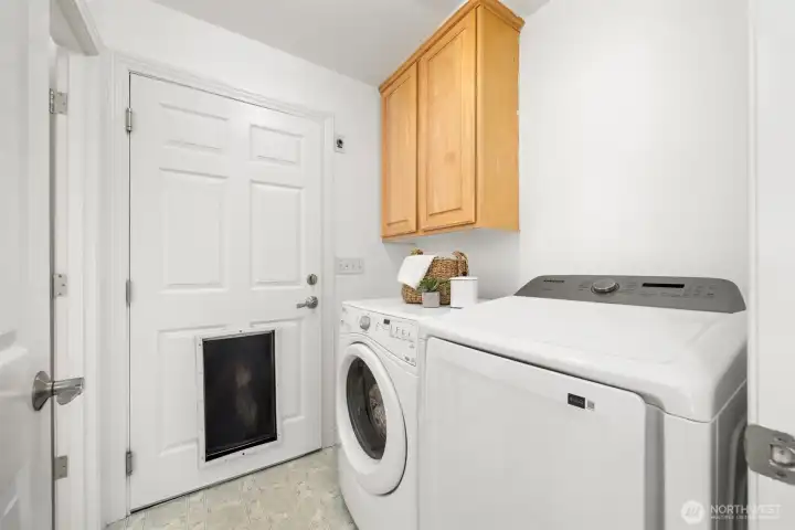 The laundry room is located off the kitchen, with a door that leads into the garage. There's also a half bath (located to the left) off of the laundry room.