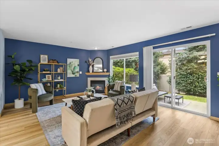 open living room featuring a cozy gas fireplace, creating a warm and comfortable atmosphere. Outside, a charming and quaint patio area is also captured, suggesting an enjoyable outdoor space.