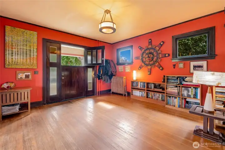 Grand entryway with rich hardwood floors, soaring ceilings, and warm character — a stunning first impression.