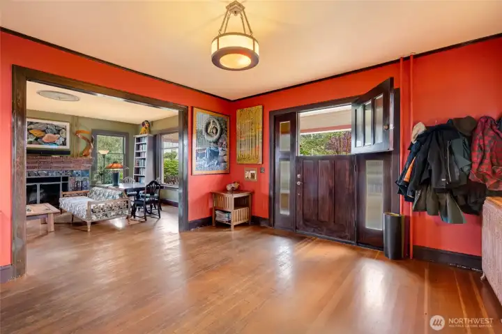 Entryway flows seamlessly into the oversized living room, showcasing the home's open layout and beautiful hardwood floors.