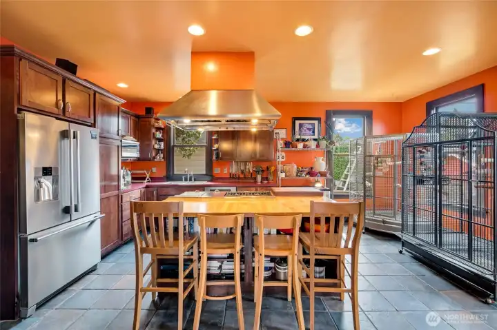 Updated kitchen with top-end appliances, professional range hood, center island with bar seating, and rich cabinetry.