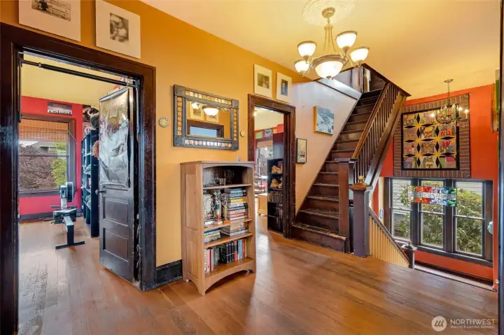 Upper hallway with the classic staircase, original hardwood floors, and the third set of stairs leading to the unfinished third floor.