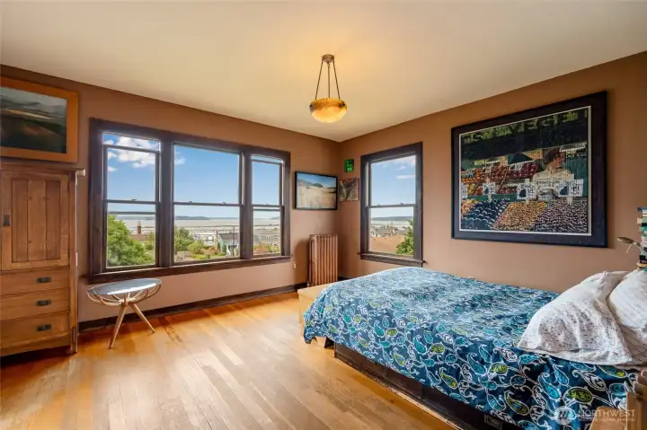 Spacious corner primary suite with western water views of the Puget Sound, hardwood floors, and serene natural light.