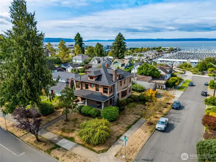 Aerial drone view of the home's large corner lot with sweeping views of the Puget Sound, marina, and Jetty Island just beyond.