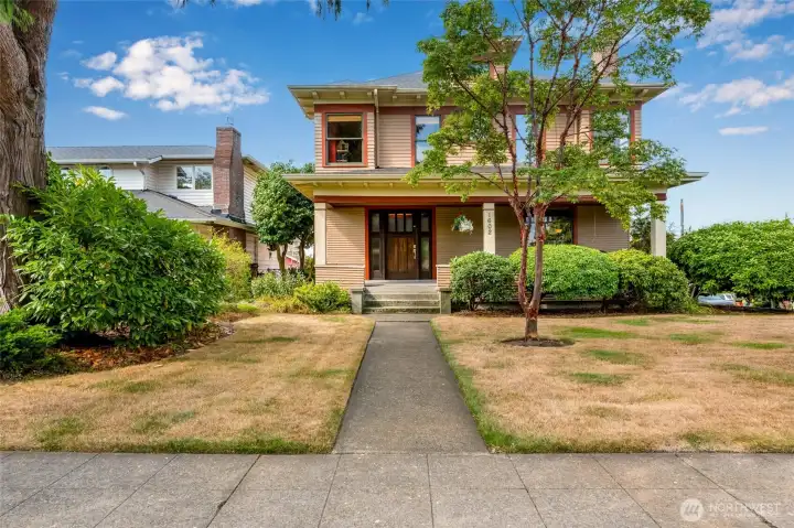 Classic Historic North Everett home with timeless craftsman charm, a grand front porch, and a welcoming walkway framed by mature trees and lush landscaping.