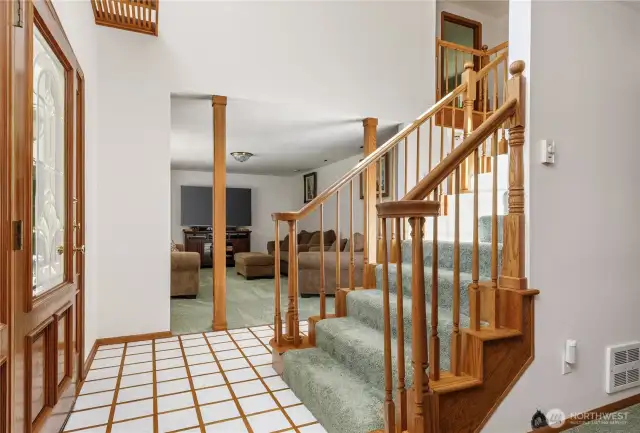 Large entry with tiles made of Mt St. Helens ash and inlaid oak, looking into the living room and beautiful staircase