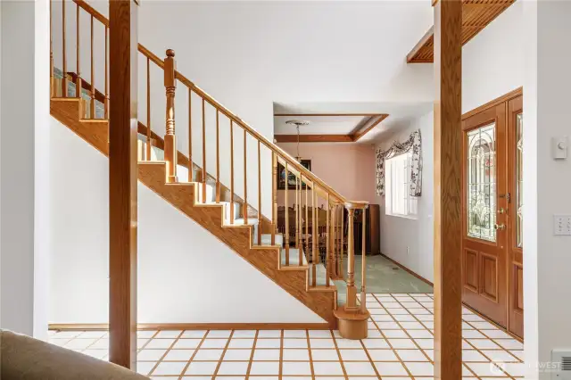View from the living room of the large staircase and inlaid entry floor