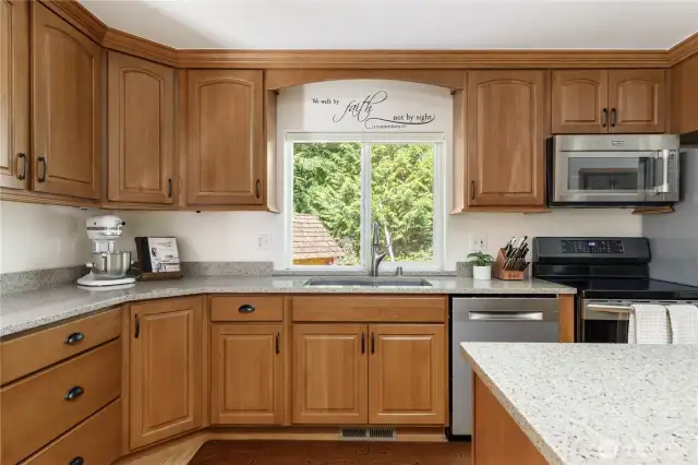 Beautiful Beechwood cabinets with under cabinet lighting, quartz countertops, Bosch dishwasher, induction range with convection and conventional oven, Maytag refrigerator and microwave