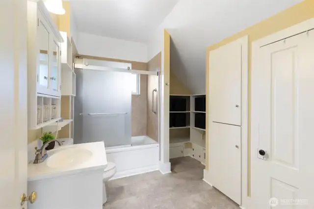 Large bathroom with linen closet and shelving storage.