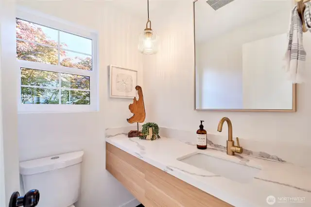 Main floor powder bath with custom floating vanity and plenty of natural light.